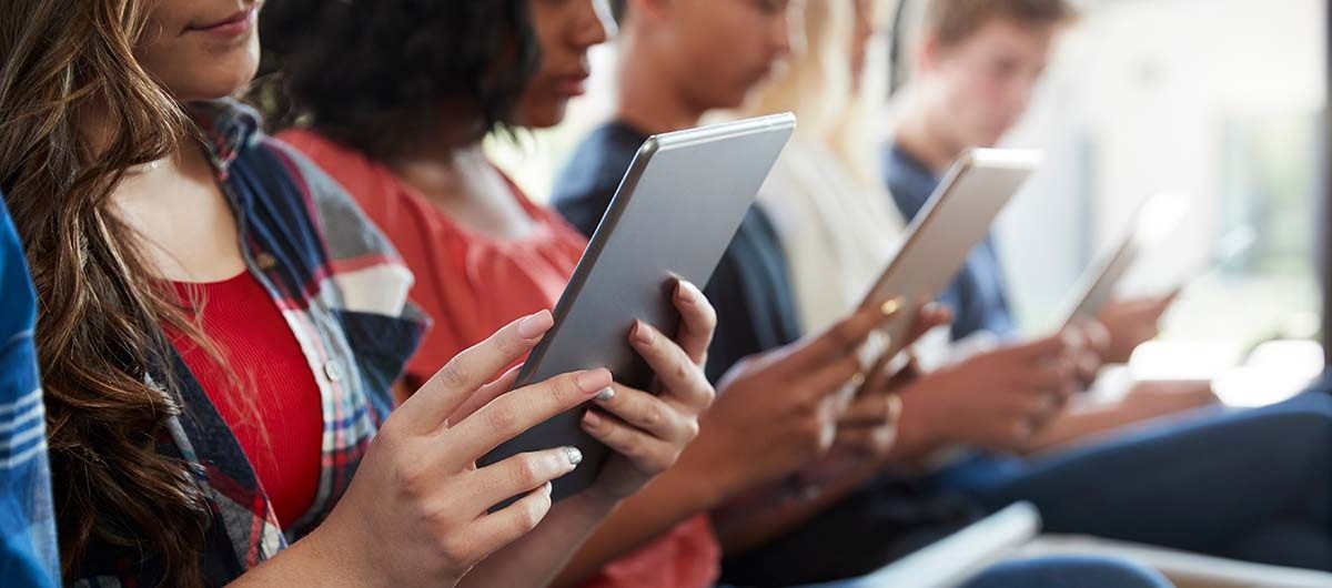 Schülerinnen und Schüler arbeiten nebeneinander an ihren Tablets